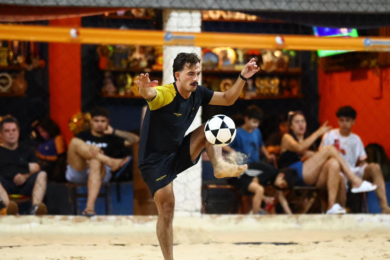 Caio, professor de futevôlei, dominando a bola durante um treino